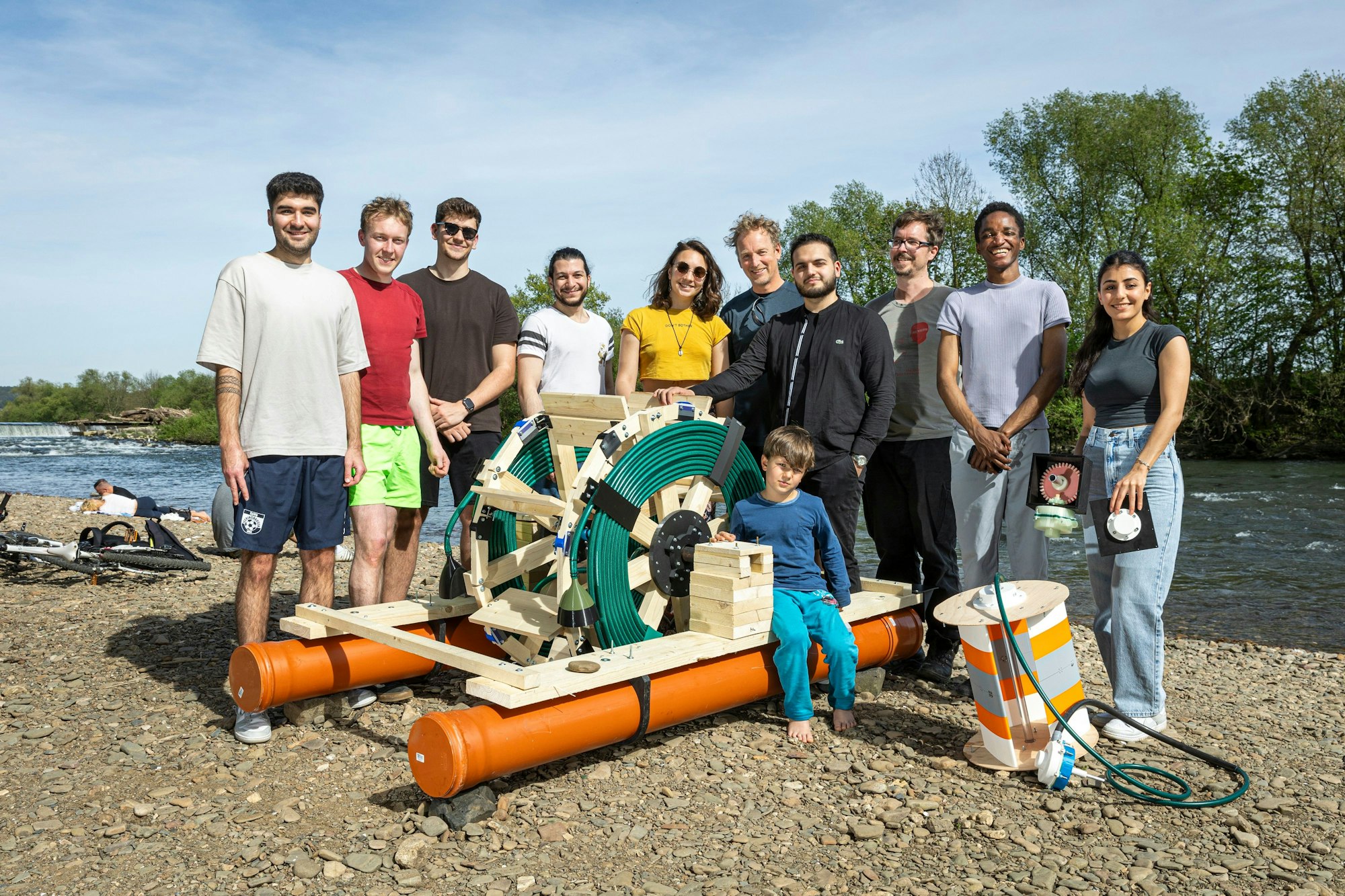 Das ganze Team mit Prof. Wellendorf (Sechster von links und Sebastian Trampnau (Dritter von rechts), die den Kurs am Institut für Allgemeinen Maschinenbau am Campus Gummersbach geleitet haben, beim Testen der Prototypen an der Sieg bei Siegburg.