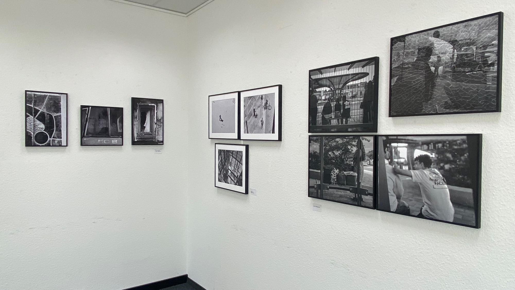 Schwarz-Weiß-Fotografien hängen an einer Wand.