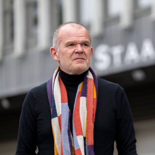 Francois-Xavier Roth, Generalmusikdirektor der Stadt Köln, steht vor dem Staatenhaus. Er trägt eine dunkle Jacke und einen gemusterten Schal.