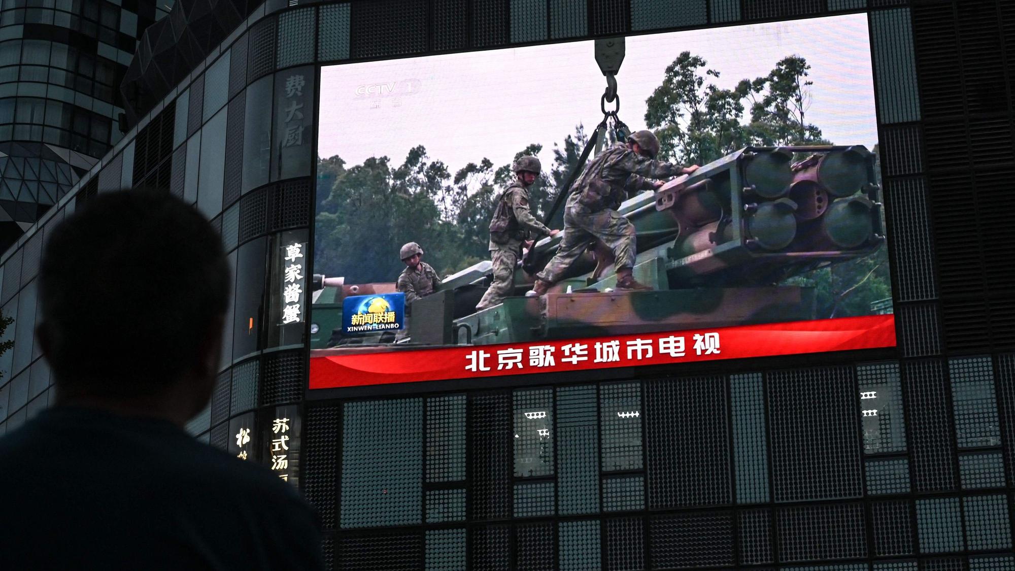 Ein Bildschirm zeigt in Peking Aufnahmen von Chinas Militärübung in der Nähe von Taiwan. China will Taiwan nach eigenen Angaben mit dem Manöver „bestrafen“.