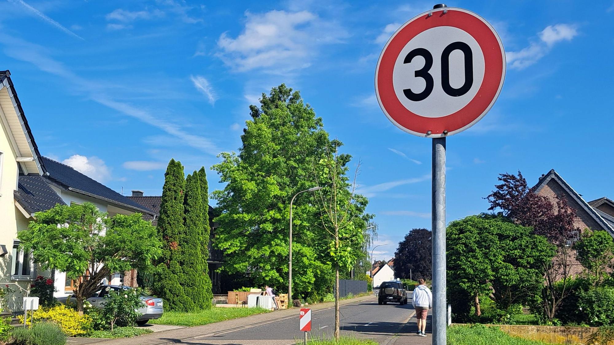 Ein Verkehrsschild ordnet auf einer Niederkasseler Straße Tempo 30 an.