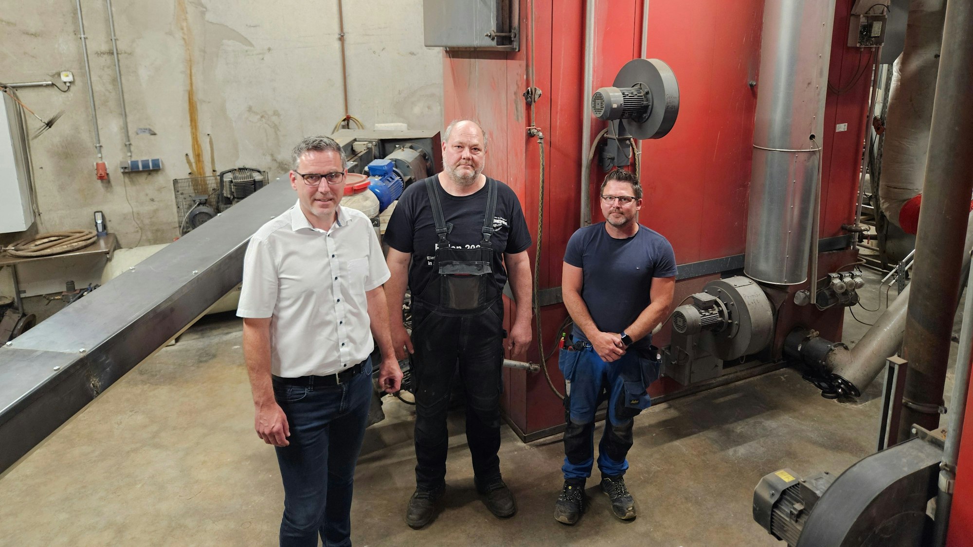 Norbert Crump, Rudolf Reetz und Reiner Hehs stehen in der Heizzentrale in Nettersheim.