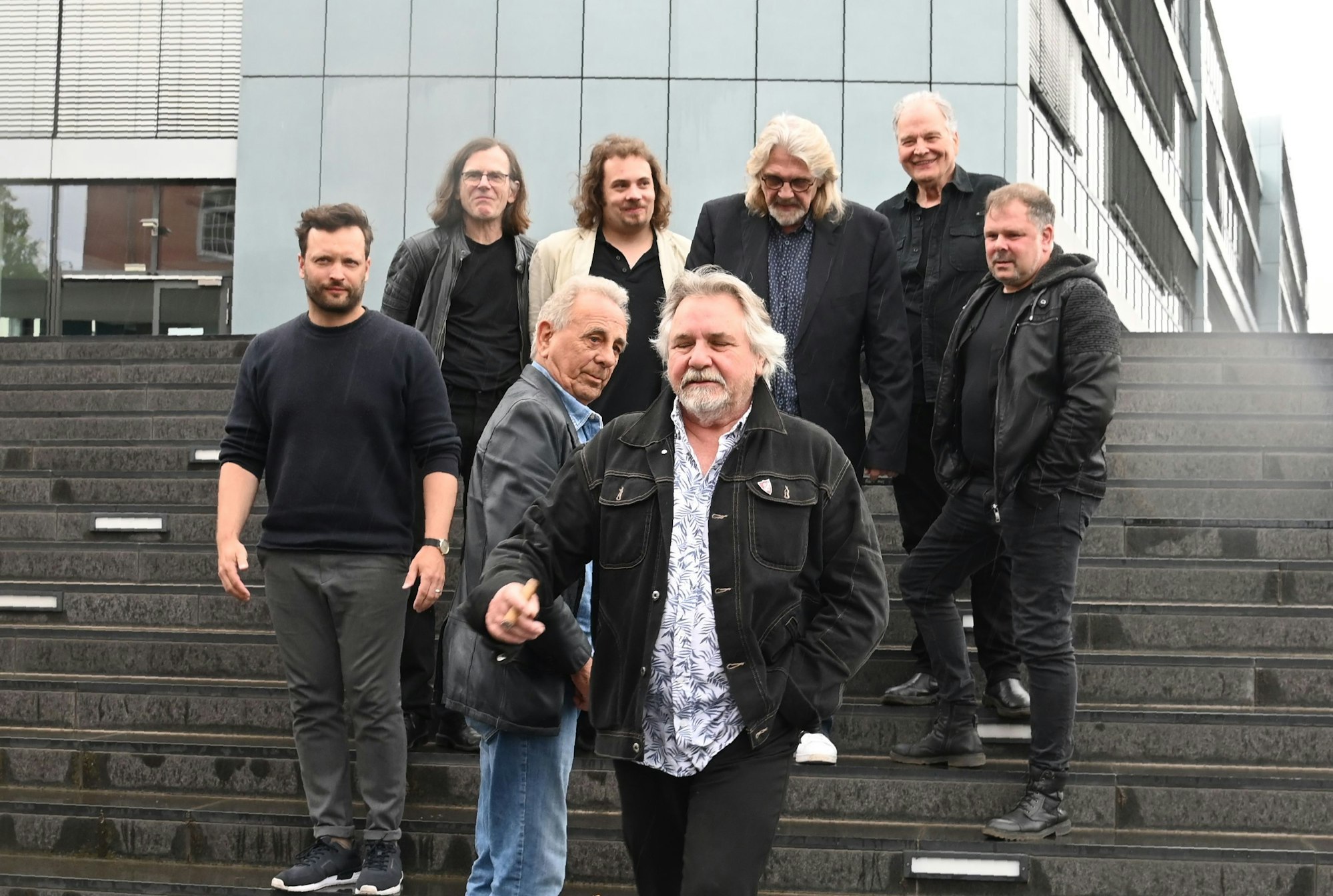 Der Weihnachtsengel stellt den diesjährigen Gast vor. Vorne v. Li.: Lukas Berg, Erry Stoklosa, Tommy Engel, Ilja Engel. Hinten von links Markus Wienströer, Robin Duns, Jürgen Fritz, Hans Maahn. Sie stehen auf einer Treppe im Rheinauhafen.