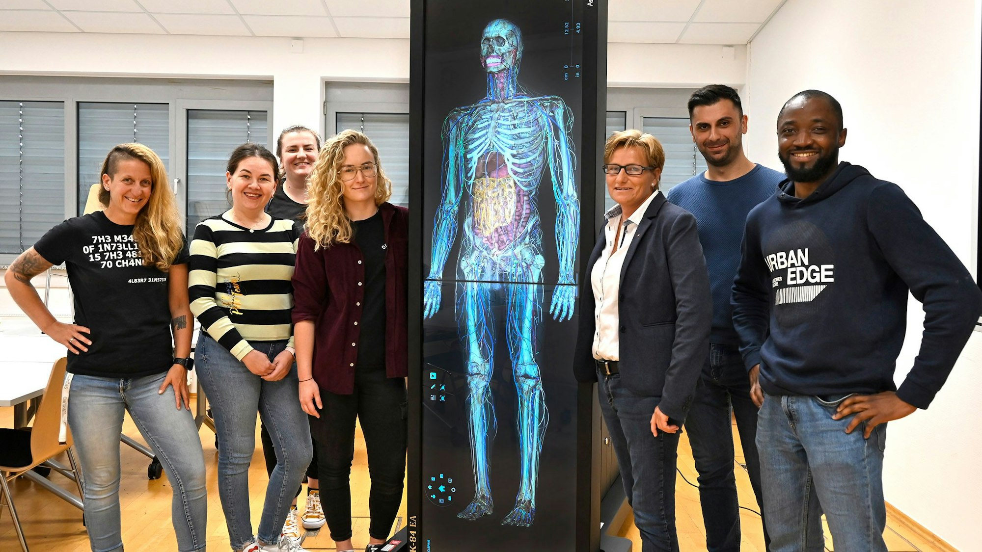 Auszubildende der Pflegeschule der Caritas Rhein-Erft mit dem neuen Anatomietisch.