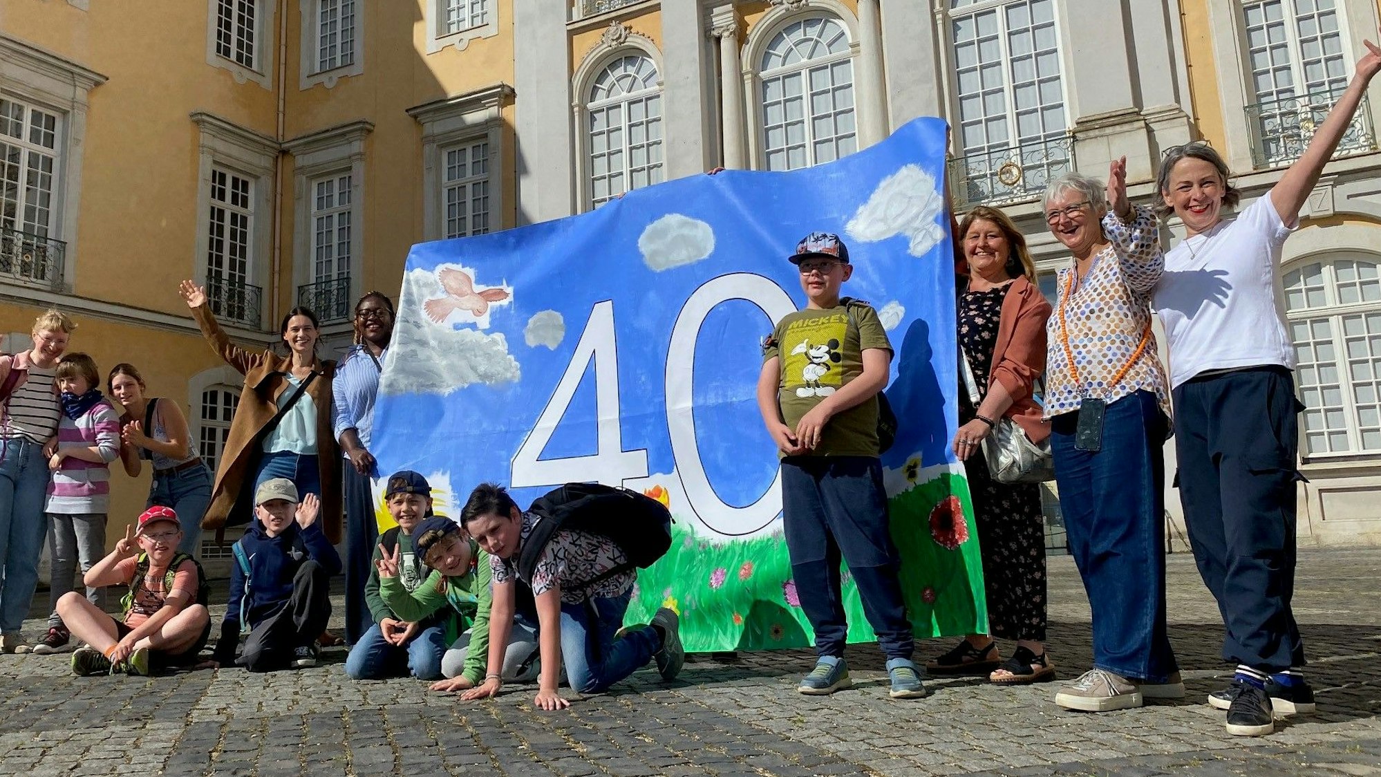 Zu sehen sind die Kinder der Maria-Montessori-Schule mit einer Plane, die eine große „40“ ziert.