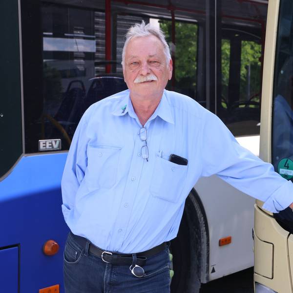 Sergej Jakowlew steht vor einem Linienbus.