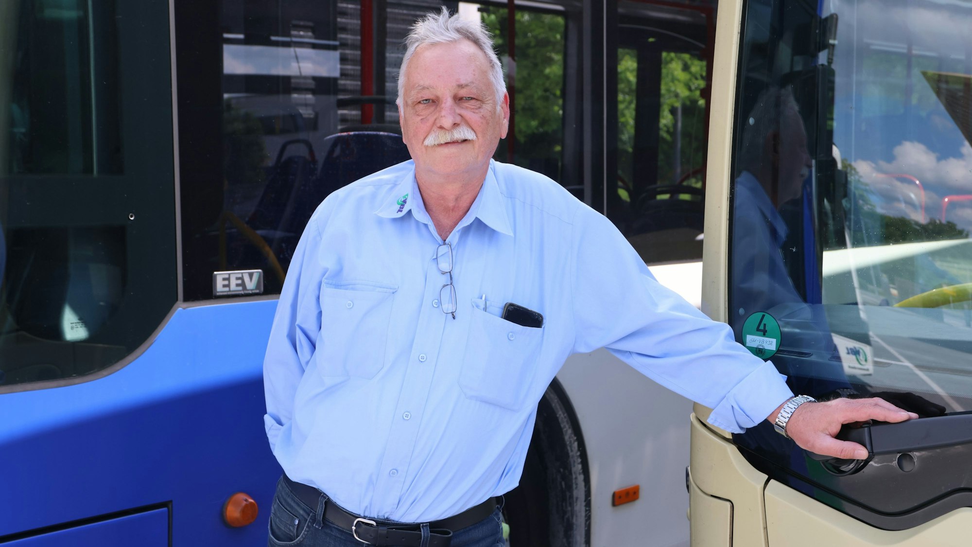 Sergej Jakowlew steht vor einem Linienbus.
