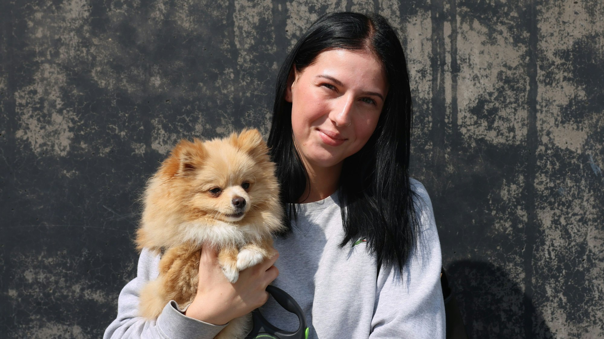 Celina Moritz im Porträt mit ihrem Hund auf dem Arm.