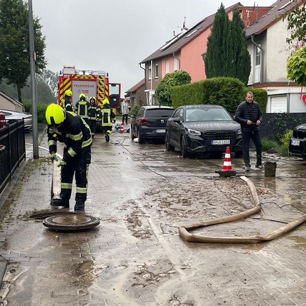 Das Foto zeigt einen Feuerwehrmann an einem Kanalschacht.