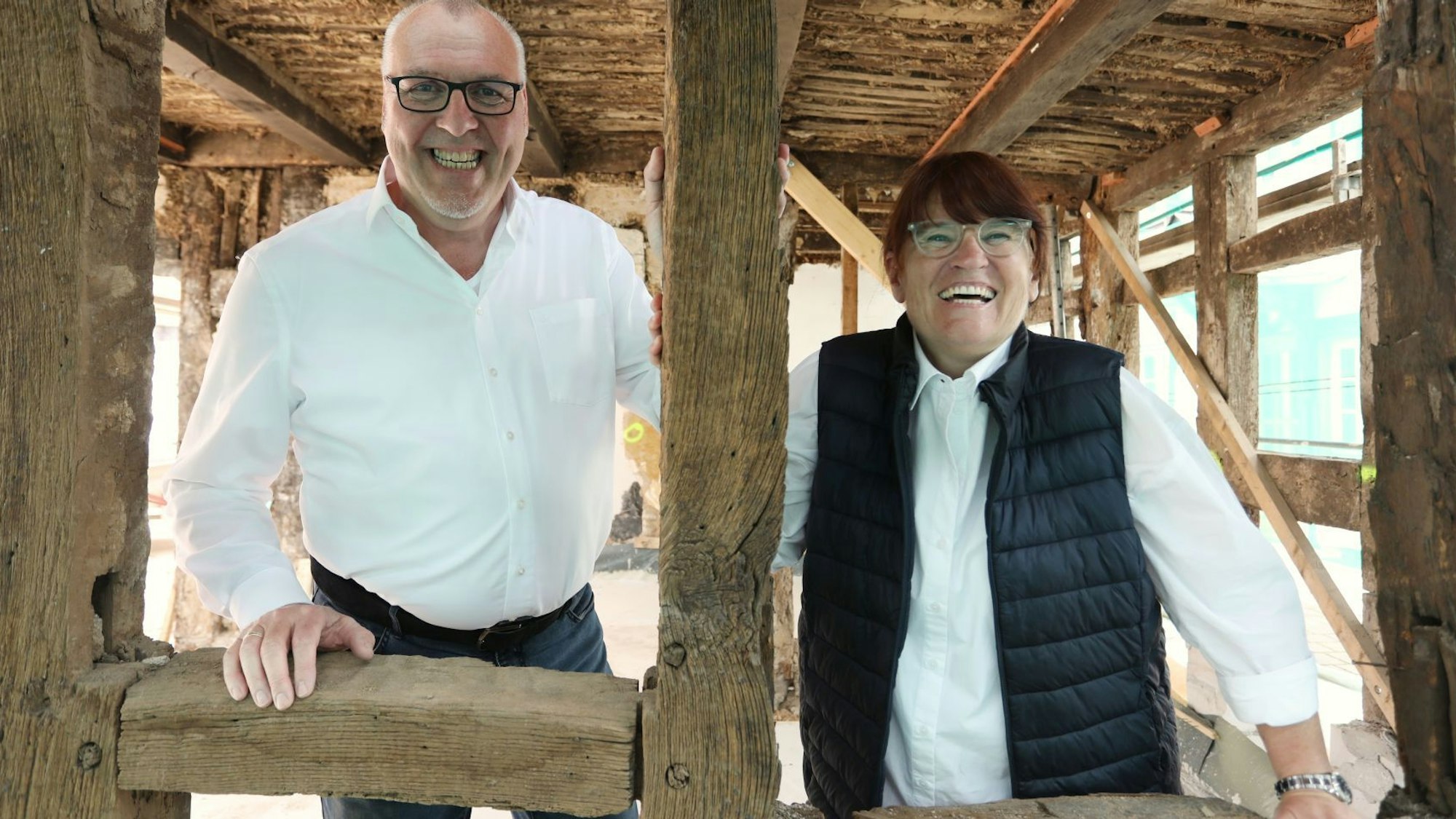 Ein Mann und eine Frau stehen im Erdgeschoss eines Fachwerkhauses.