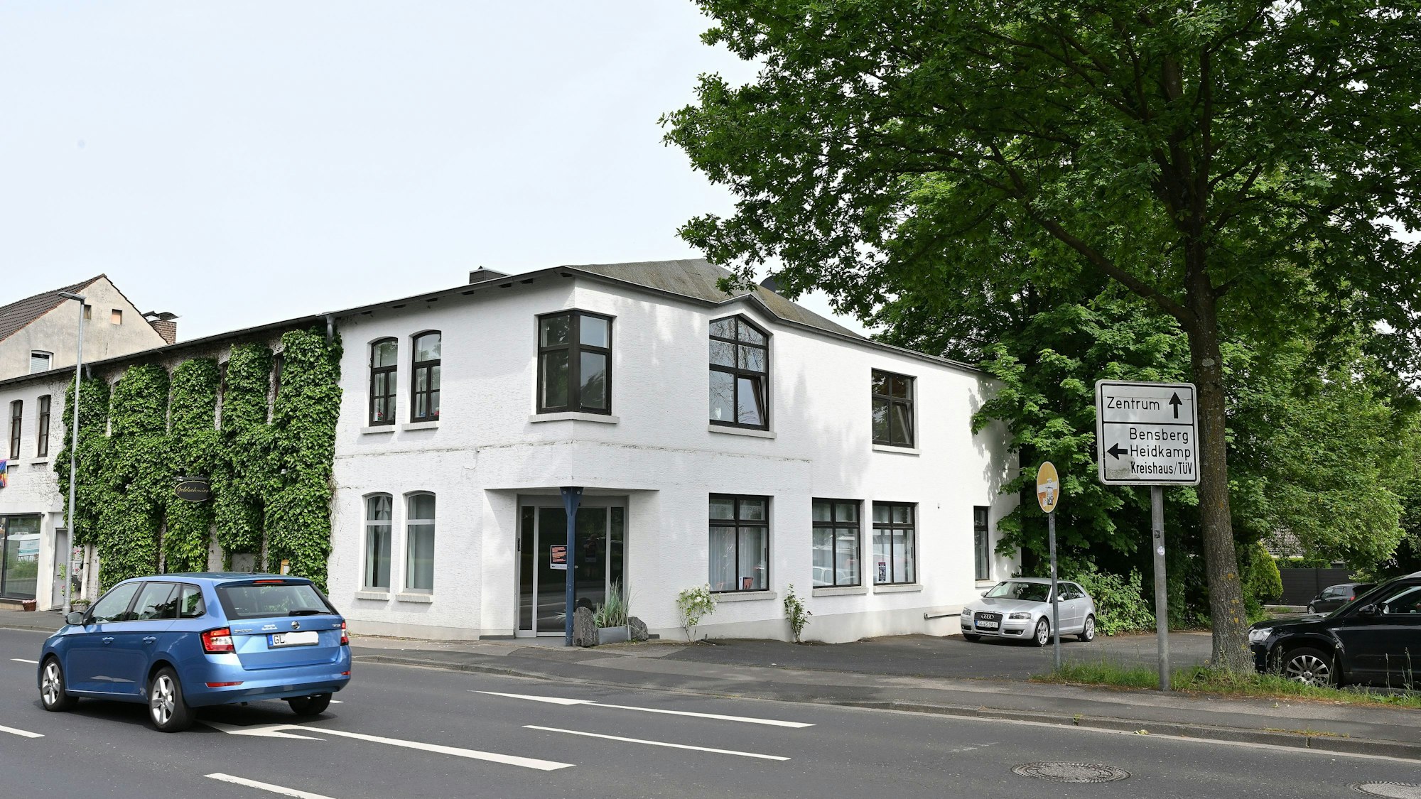 Zu sehen ist das zweistöckige Gebäude der ehemaligen Bankfiliale, das direkt an der Straße liegt.