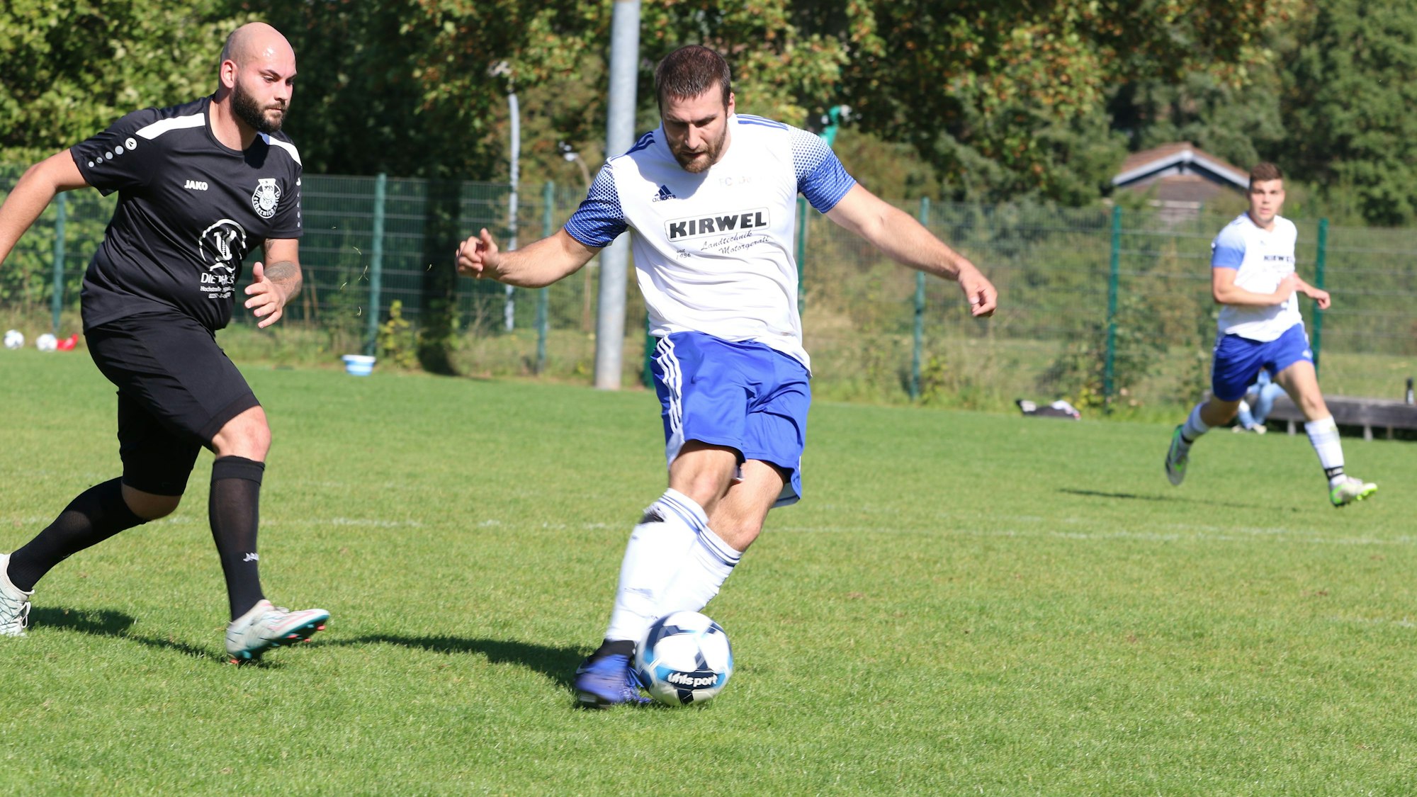 Das Bild zeigt Alexander Huth, wie er einen Ball schießt. Sein Gegenspieler kommt zu spät.