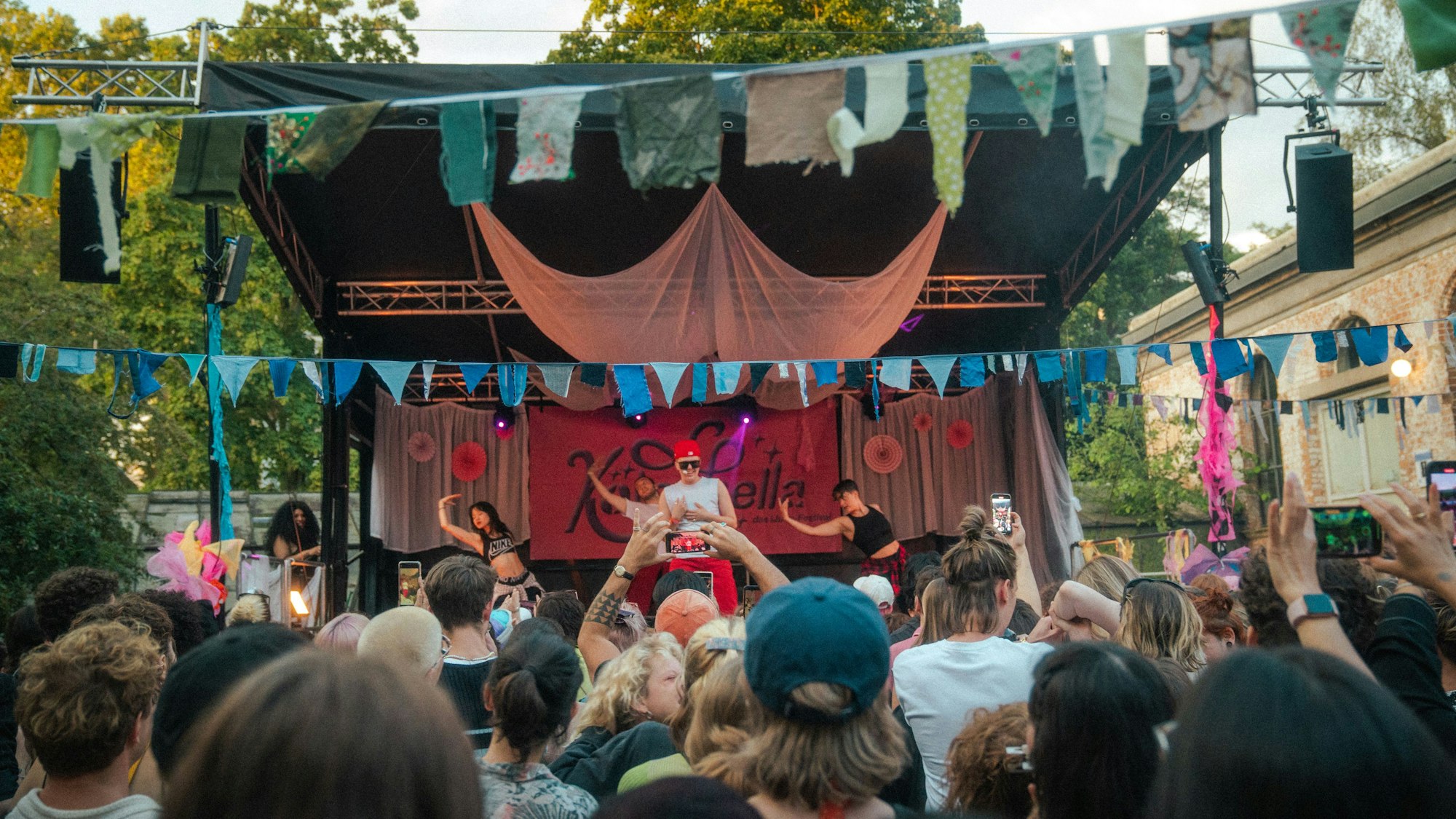 Menschen stehen vor einer Bühne.