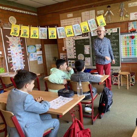 Jean-Jacques Rousseau unterrichtet in einem Klassenzimmer in Manderfeld Deutsch für Kinder von Geflüchteten an der Clara Viebig Gemeindeschule.