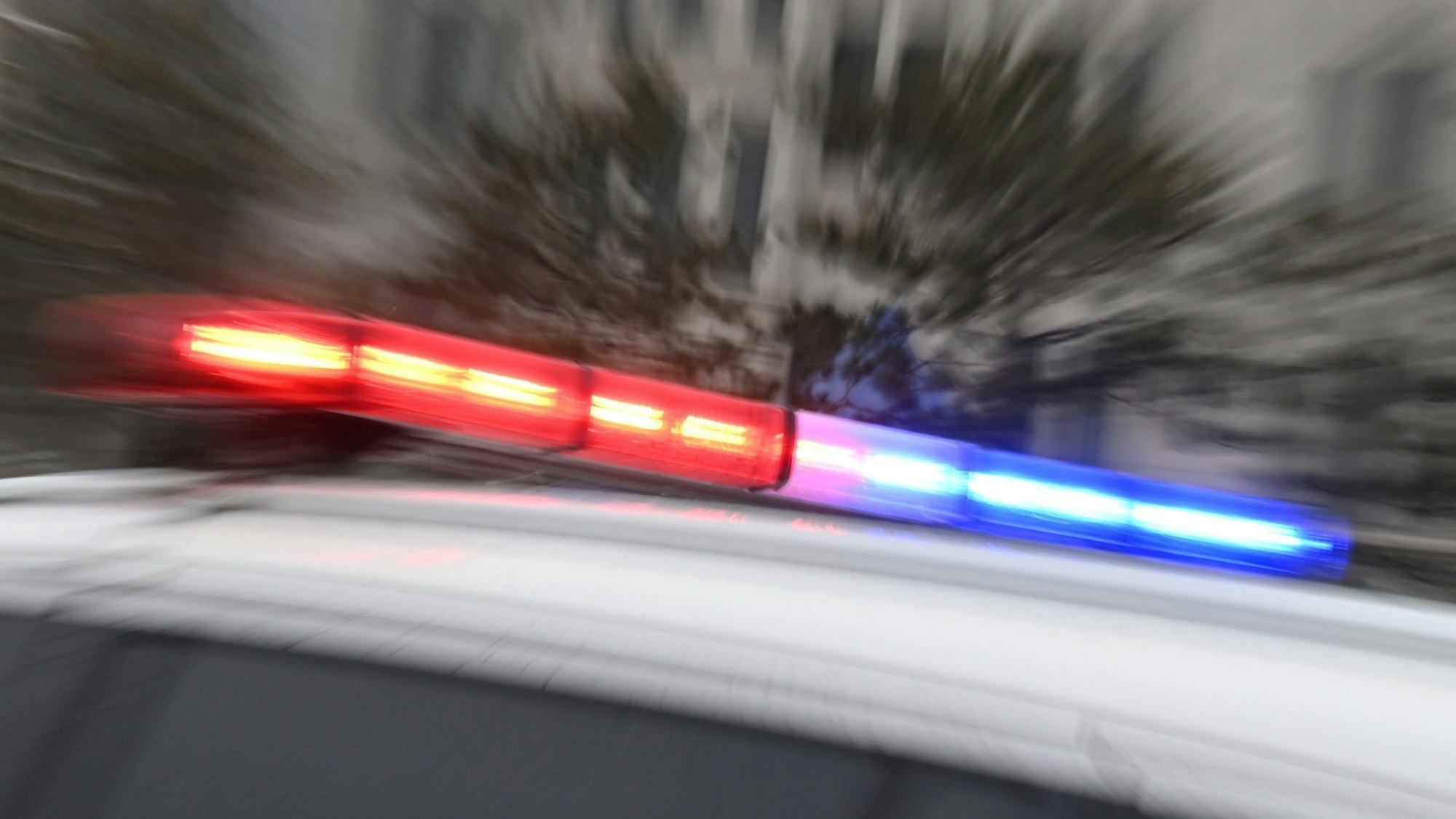 Auf einem weißen Polizeiwagen blinken rot-blaue Polizeilichter.((Symbolbild)