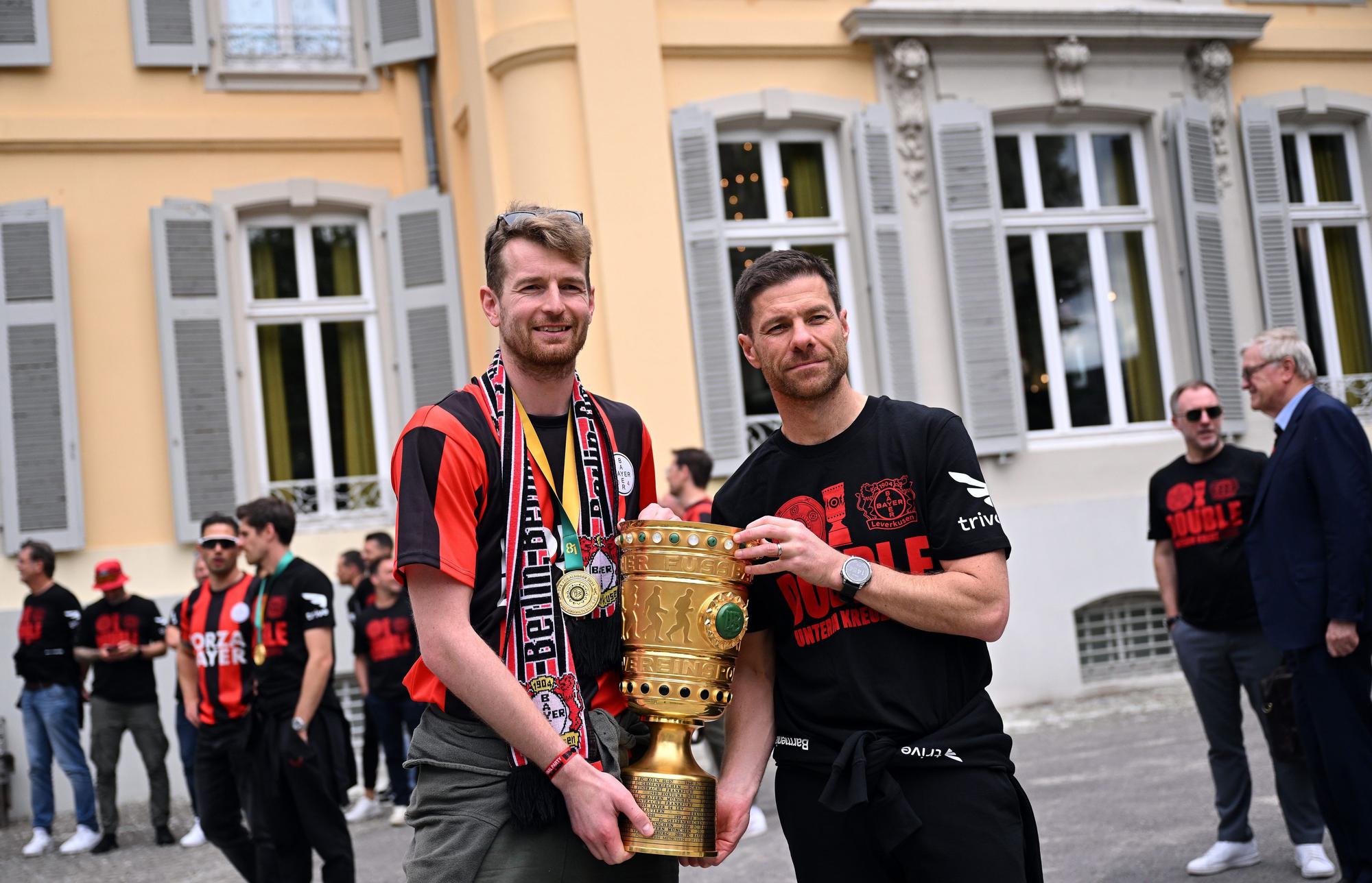 Leverkusens Torhüter Lukas Hradecky (l) und Leverkusens Trainer Xabi Alonso kommen mit dem Pokal zum Schloss Morsbroich, um sich in das Goldene Buch der Stadt einzutragen.