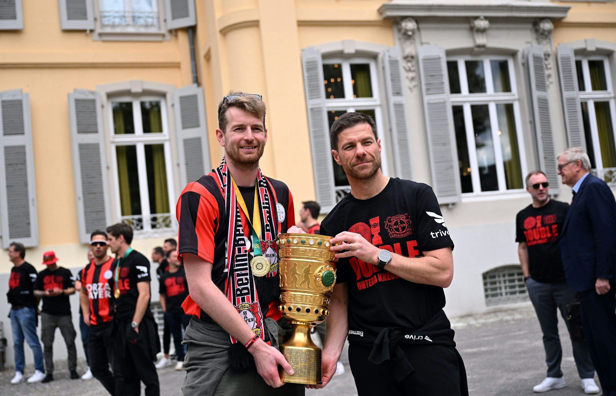 Leverkusens Torhüter Lukas Hradecky (l) und Leverkusens Trainer Xabi Alonso kommen mit dem Pokal zum Schloss Morsbroich, um sich in das Goldene Buch der Stadt einzutragen.