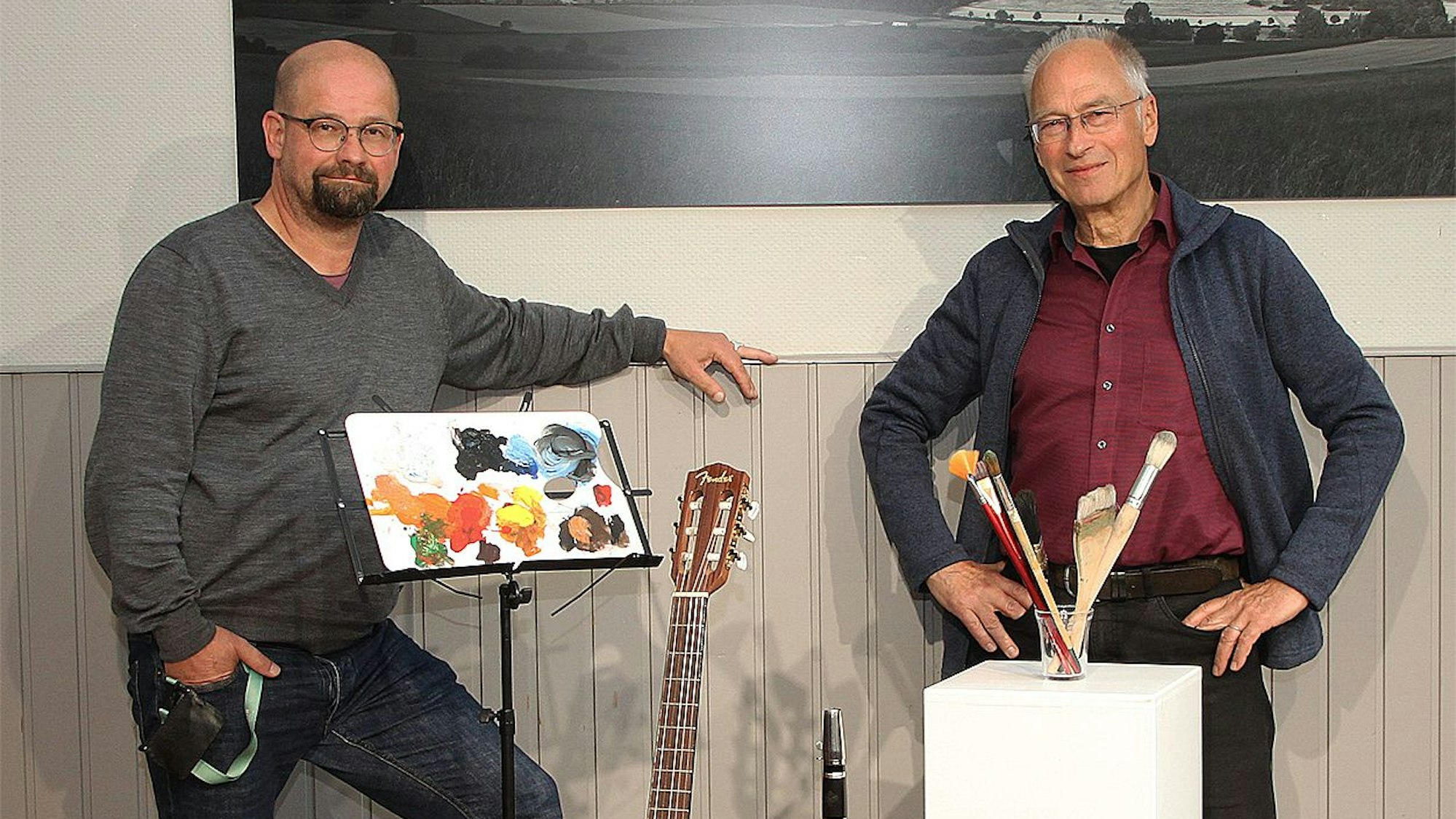 Schöddert und Igelmund blicken freundlich in die Kamera, vor ihnen Instrumente und Malerpinsel als Symbole für das Kulturfestival.