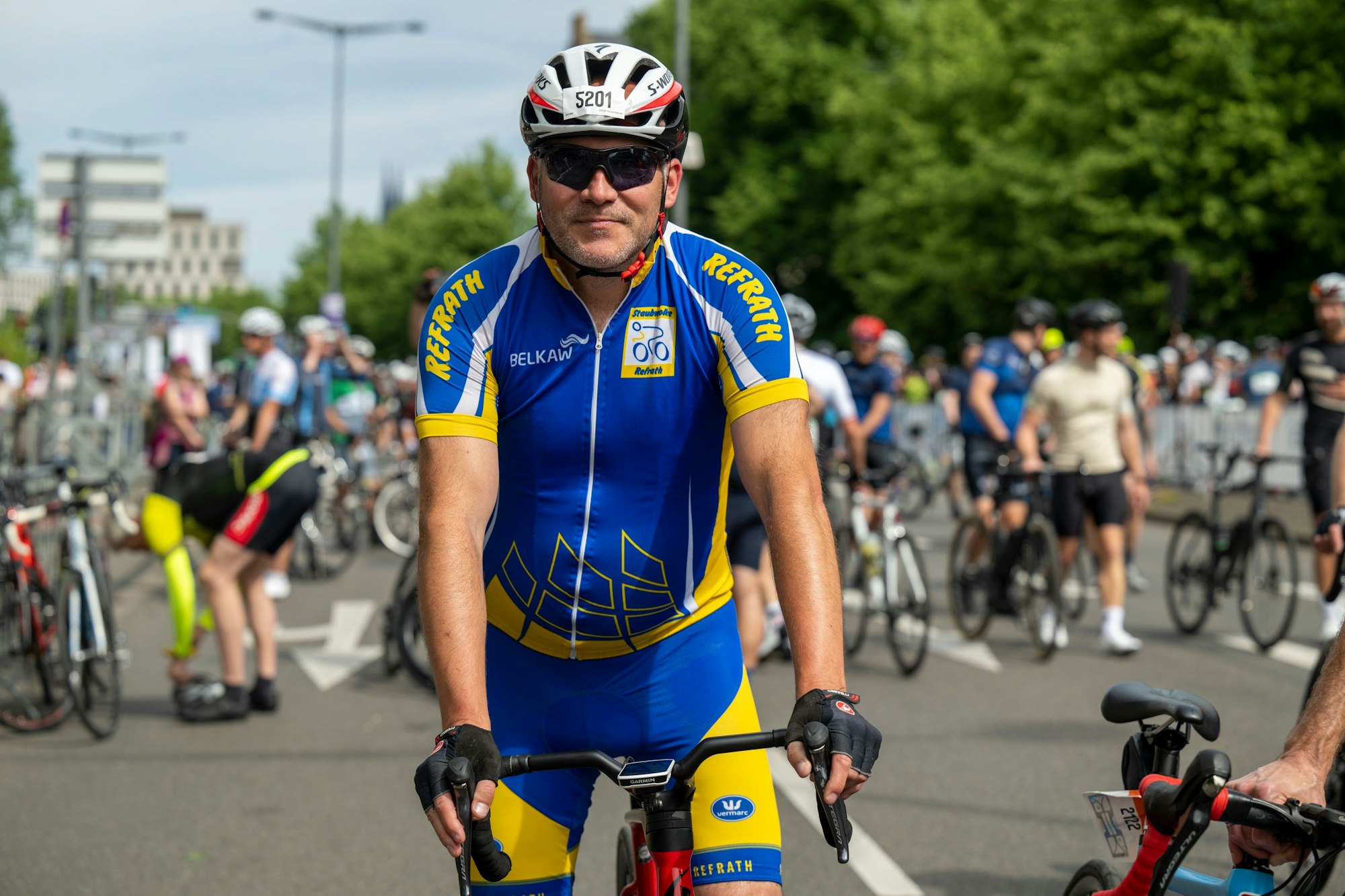 Mann mit blau-gelbem Trikot sitzt auf Rennrad.
