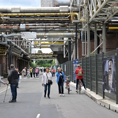 Menschen gehen über die „Mainstreet“ auf dem Zanders-Gelände.