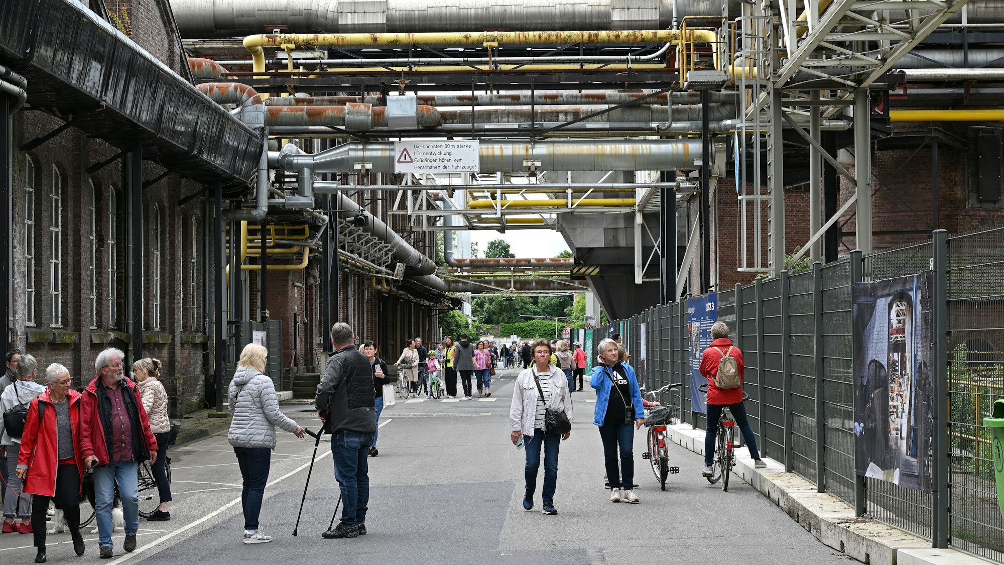 Menschen gehen über die „Mainstreet“ auf dem Zanders-Gelände.
