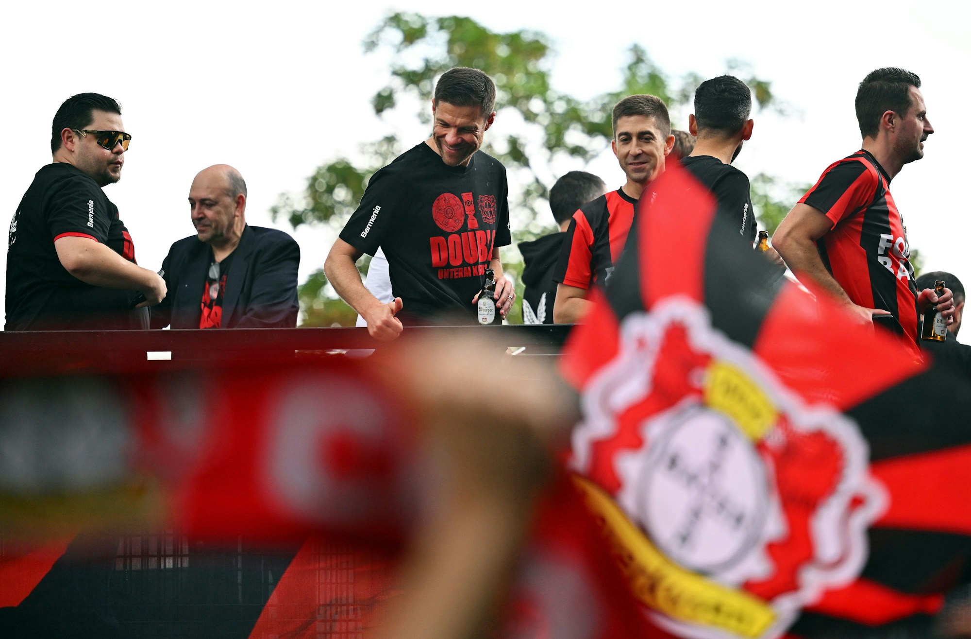 Leverkusens Trainer Xabi Alonso (M) und seine Spieler fahren bei einem Autokorso von Schloss Morsbroich zur BayArena in einem offenen Bus durch die Stadt.