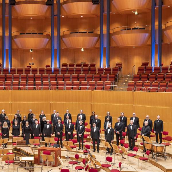 Die Mitglieder des KölnChor haben sich auf der Bühne der Kölner Philharmonie aufgestellt. Sie tragen schwarz.