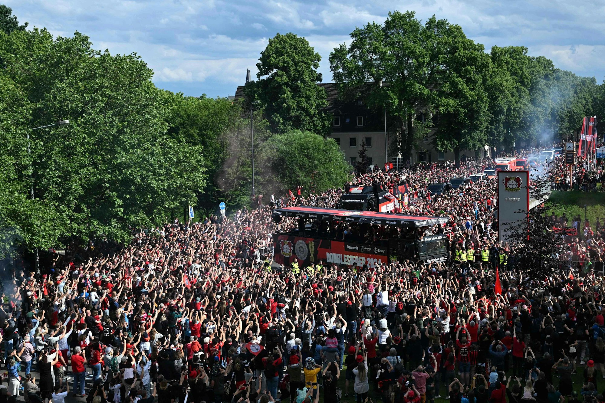 Bayer Leverkusen's players celebrate with the Bundesliga trophy and the German cup (DFB Pokal) trophy with their fans during a victory parade in Leverkusen, western Germany, on May 26, 2024. Bayer Leverkusen became the first team in the Bundesliga history to go through an entire season unbeaten. (Photo by INA FASSBENDER / AFP)