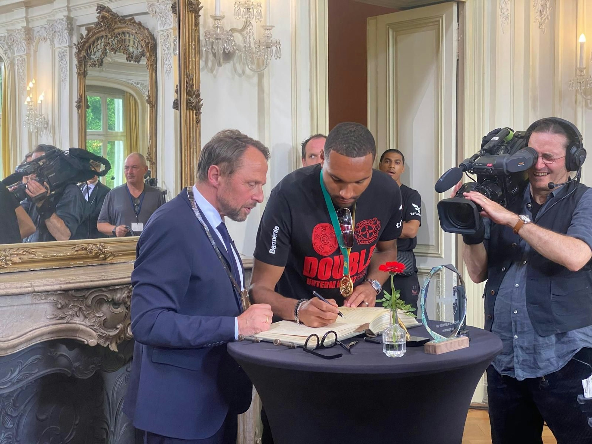 Jonathan Tah trägt sich ins goldene Buch ein.