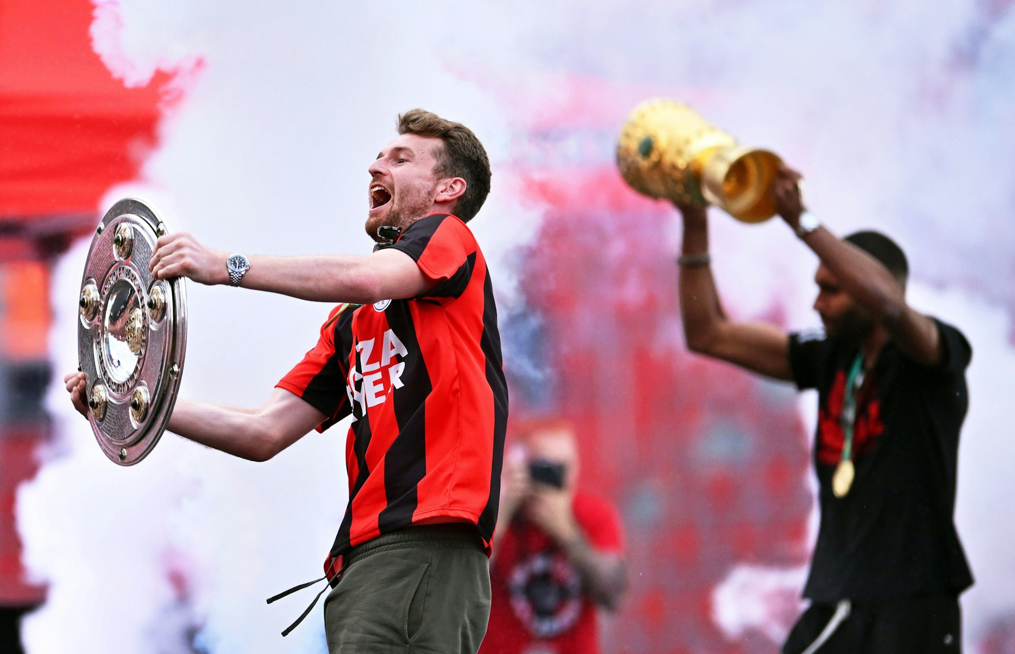 Leverkusens Torhüter Lukas Hradecky (l) und Leverkusens Jonathan Tah präsentieren bei der Meisterfeier in der BayArena die Meisterschale und den Pokal.