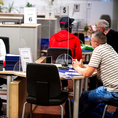 Ein Blick in die Zulassungsstelle mit Personal und Kunden.