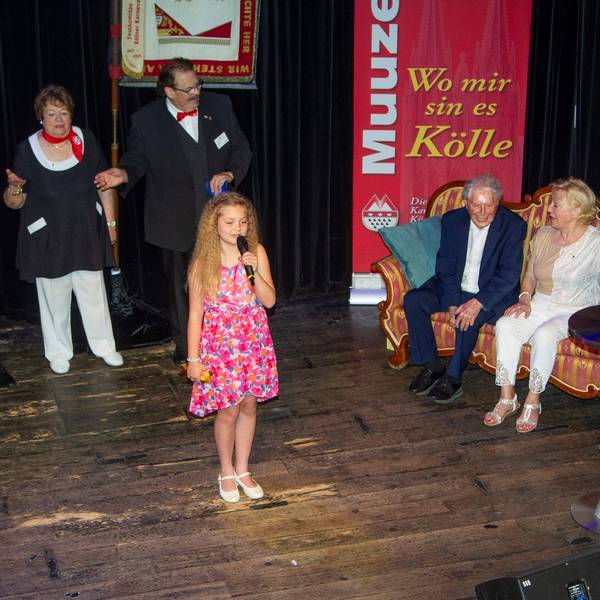Muuzemändelcher feiern 75 Jahre. In der Mitte steht das jüngste Mitglied Merle, auf dem Sofa sitzen Ludwig Sebus und Renate Baum, daneben steht der Baas, Joachim Badura.