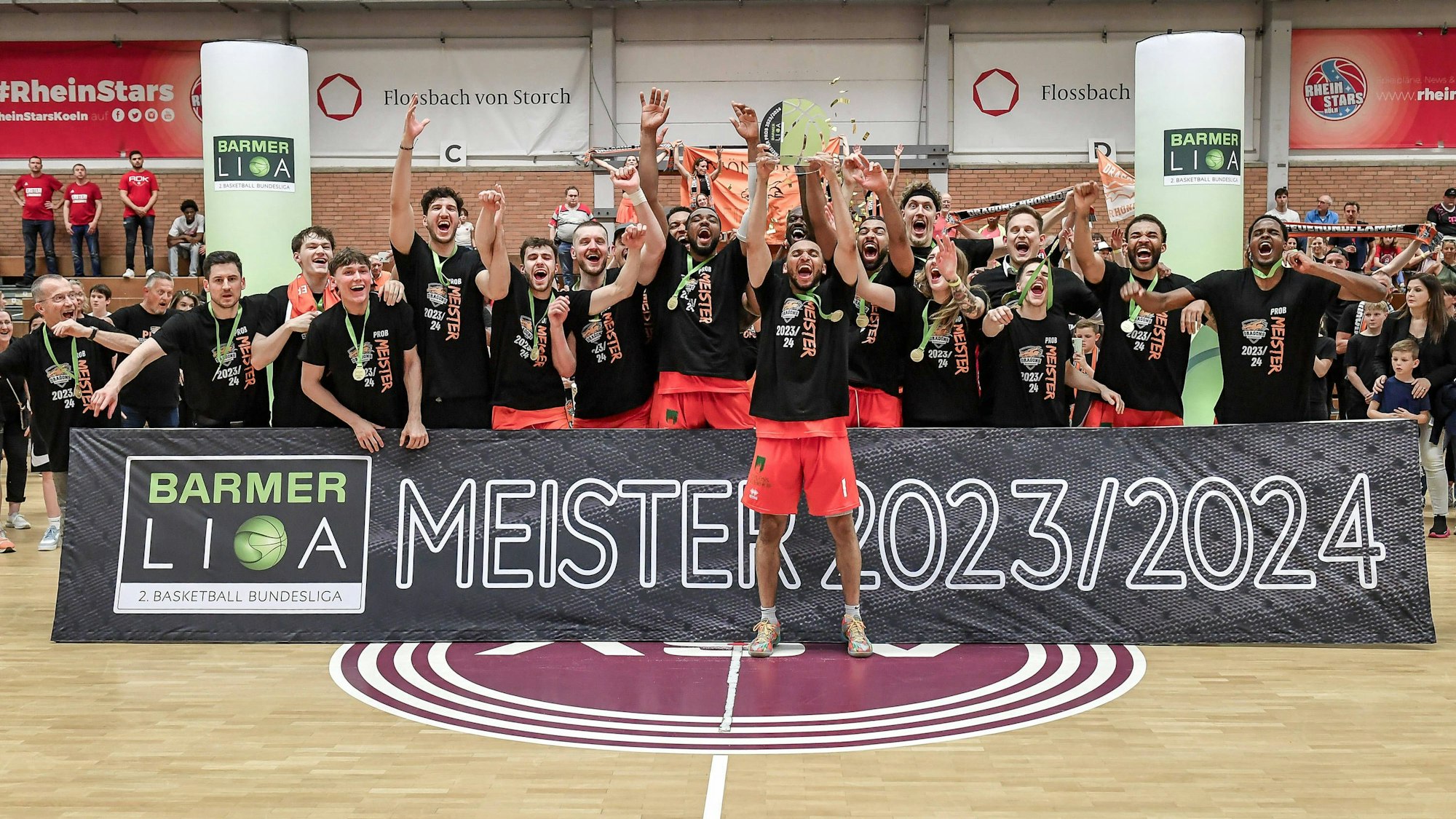 So sehen Sieger aus: Kapitän Kelvin Omojola von den Dragons Rhöndorf präsentiert den Meister-Pokal.