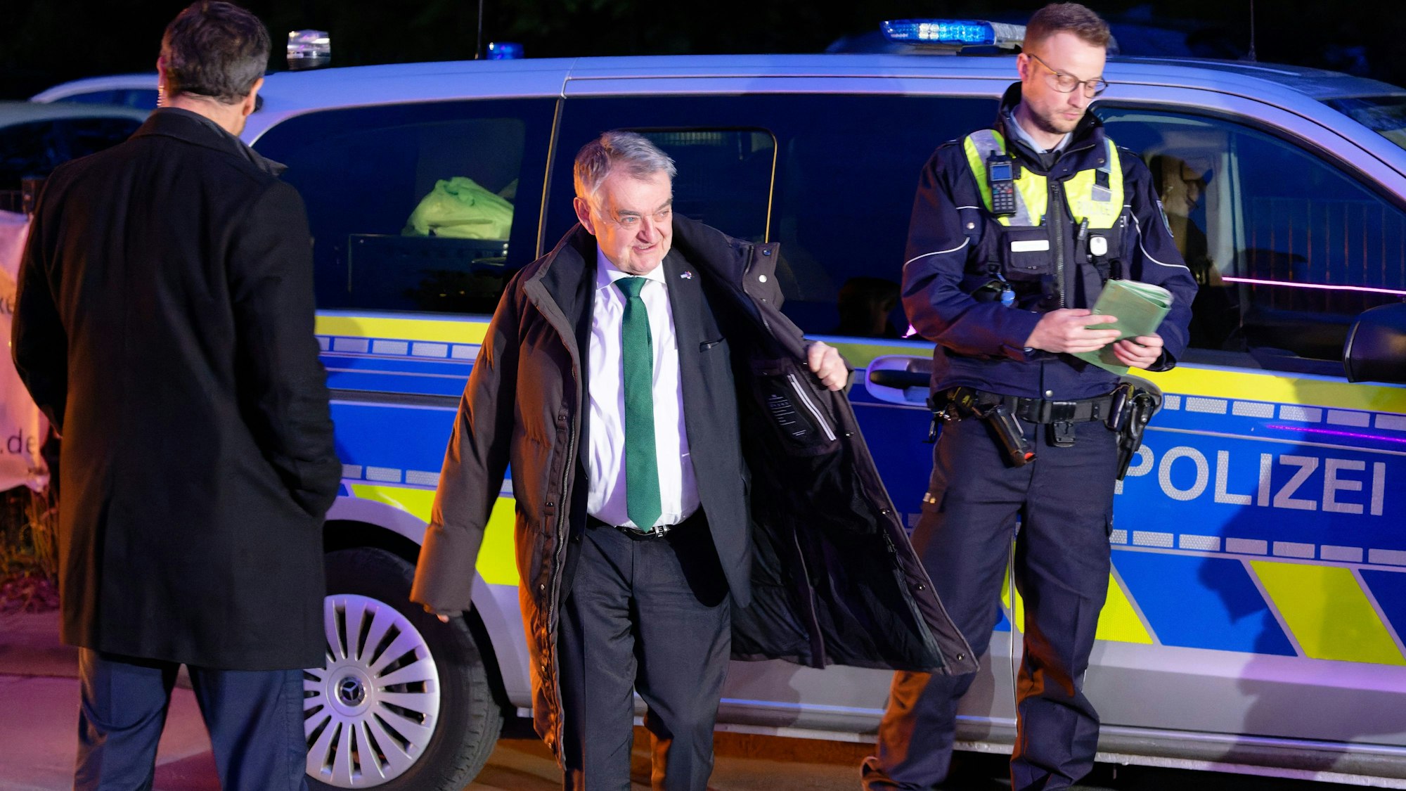 Herbert Reul (CDU), Innenminister von Nordrhein-Westfalen, steigt während einer Razzia in einem Saunaclub aus einem Polizeiauto.