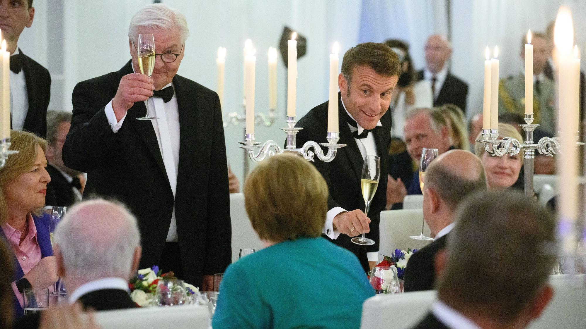 Berlin: Emmanuel Macron, Präsident von Frankreich, und Bundespräsident Frank-Walter Steinmeier (l) stoßen beim Staatsbankett zu Ehren des Präsidenten von Frankreich, Macron, und seiner Frau im Schloss Bellevue mit Bundeskanzler Angela Merkel (CDU), Bundeskanzlerin a.D., und Olaf Scholz (SPD) an.
