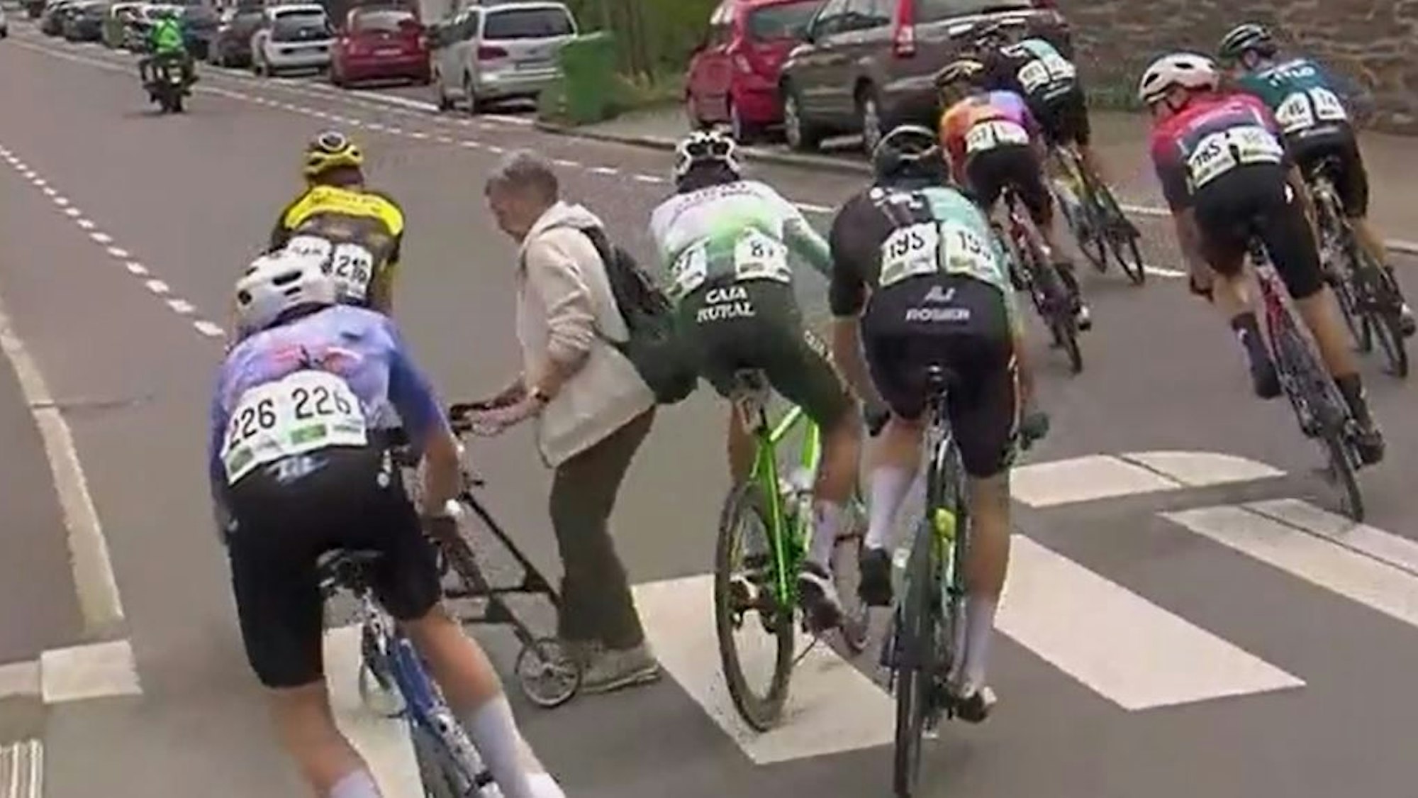 Eine Frau mit Rollator überquerte beim Radrennen „Rund um Köln“ bei der Durchfahrt in Wipperfürth die Straße.