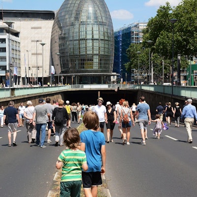 Zu sehen sind Menschen, die über eine autofreie Nord-Süd-Fahrt in Köln laufen.