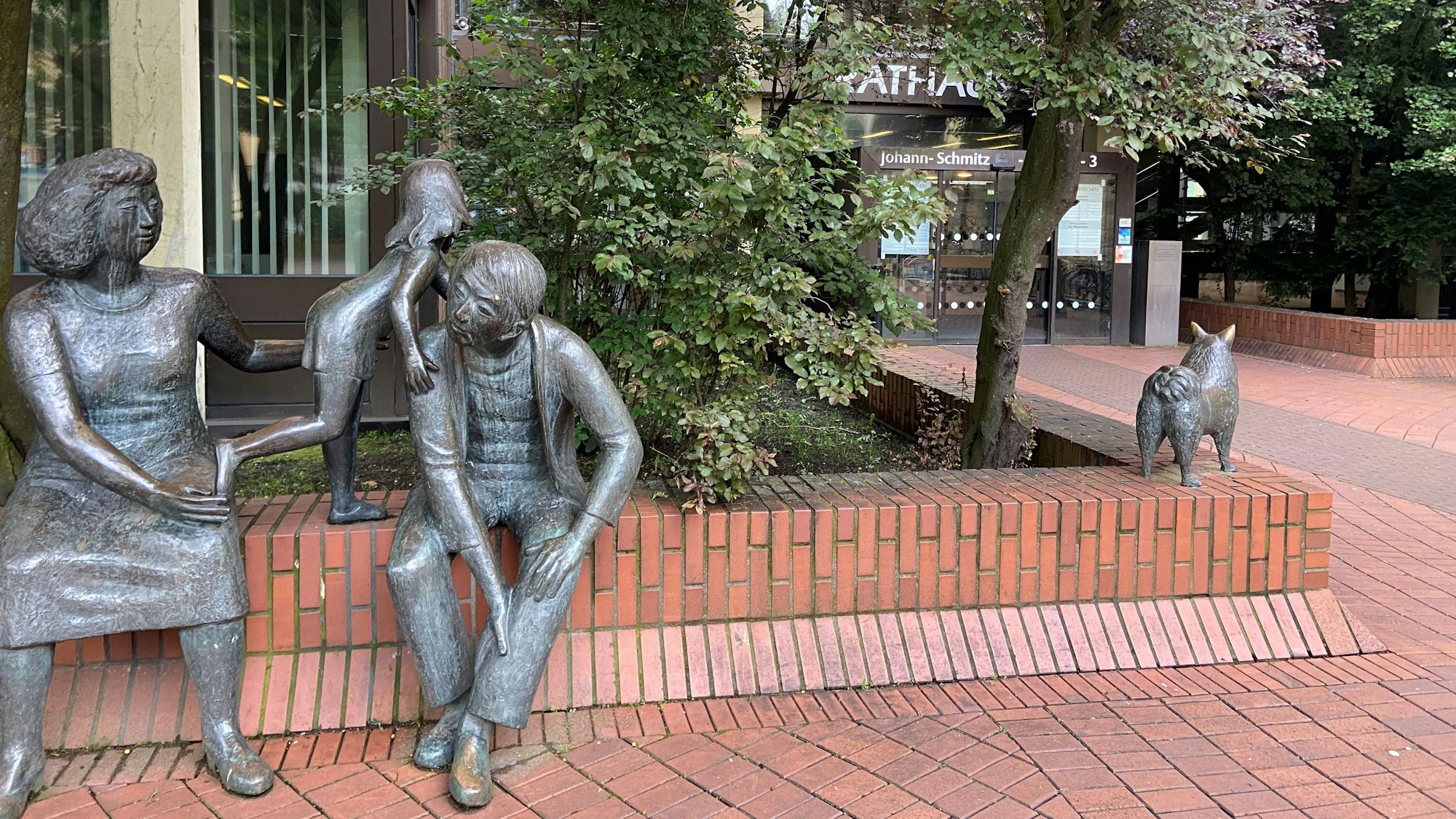 Auf dem Bild ist eine Figurengruppe aus Bronze vor dem Rathaus zu sehen.