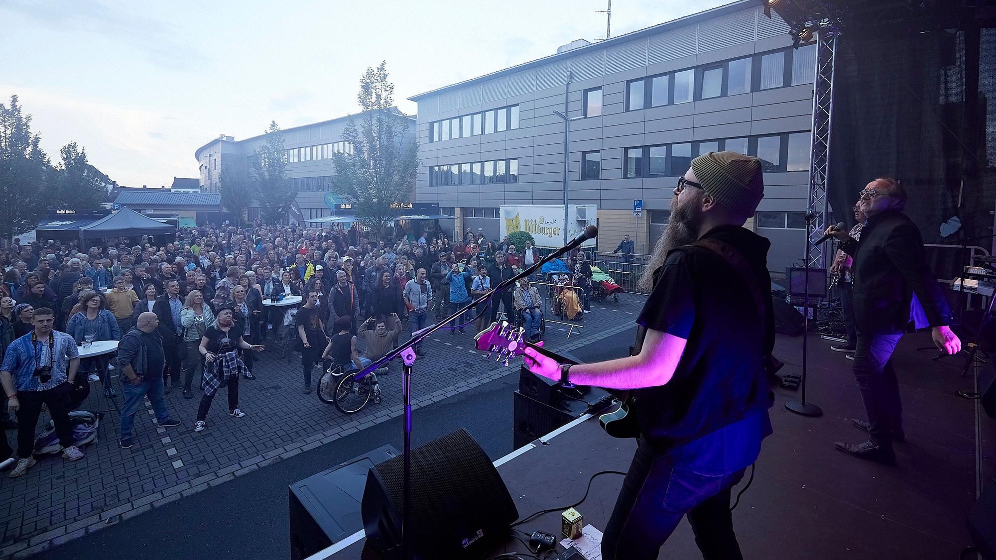 Vor der Band auf der Bühne sieht man das Publikum.