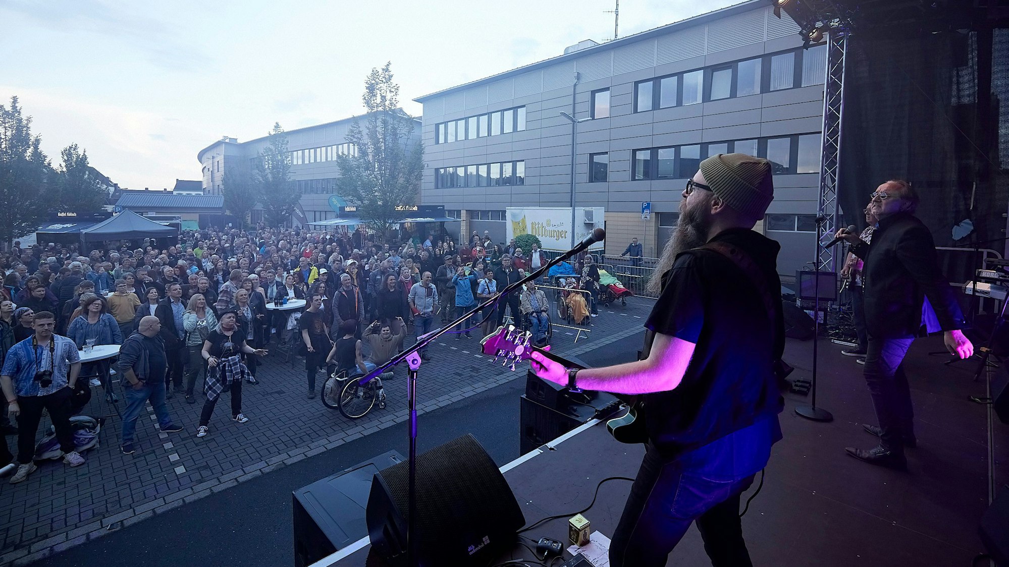Vor der Band auf der Bühne sieht man das Publikum.