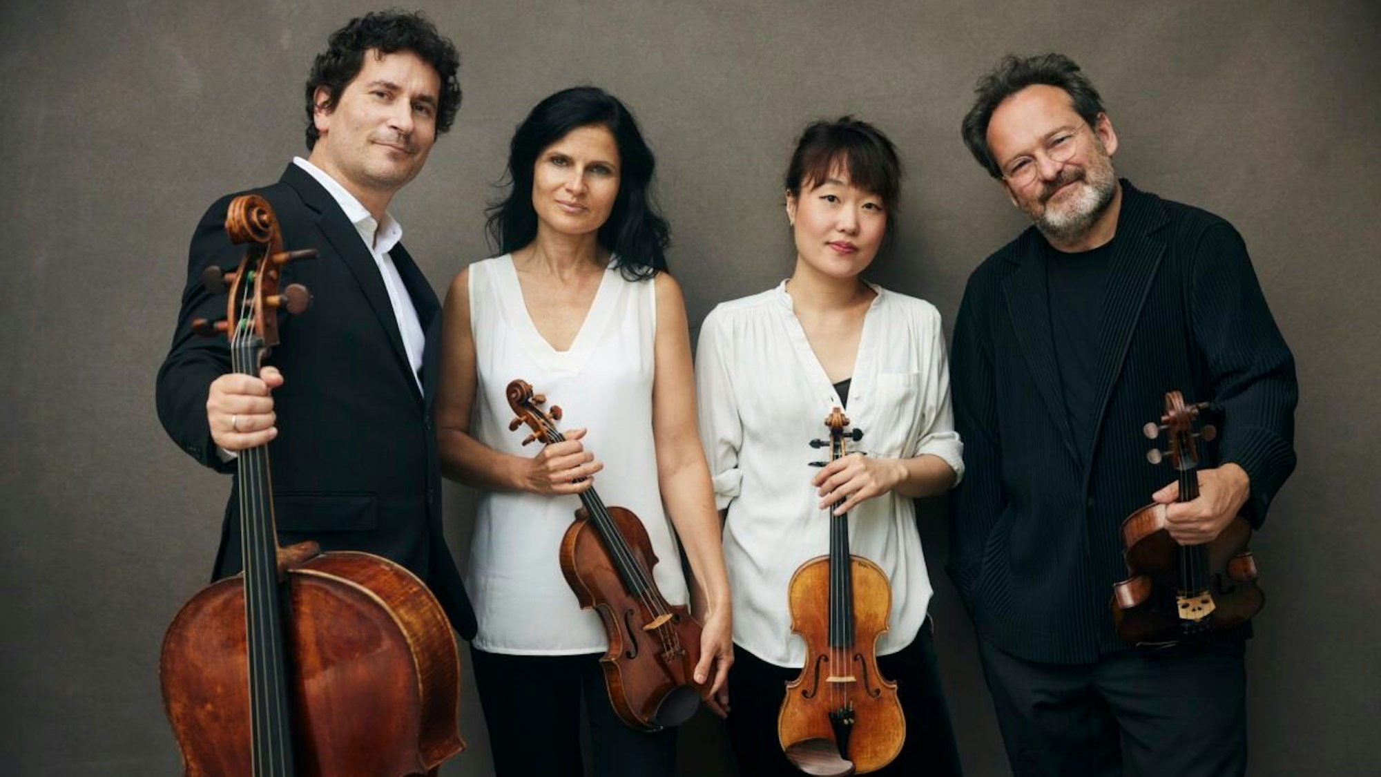 Auf dem Bild sieht man die Musikerinnen und Musiker des Quartetts. Die beiden Herren stehen außen und tragen Schwarz, die Damen innen tragen Weiß. Alle vier halten ihre Instrumente vor sich.