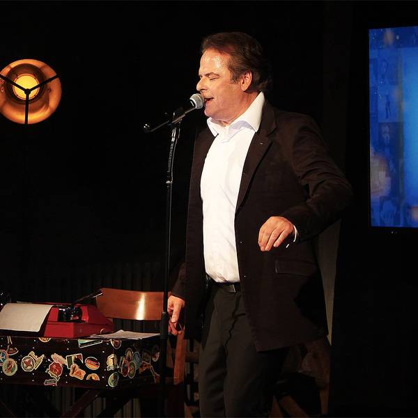 Auf einer abgedunkelten Bühne in Steinfeld steht der Sänger und Schauspieler Stephan Hippe.