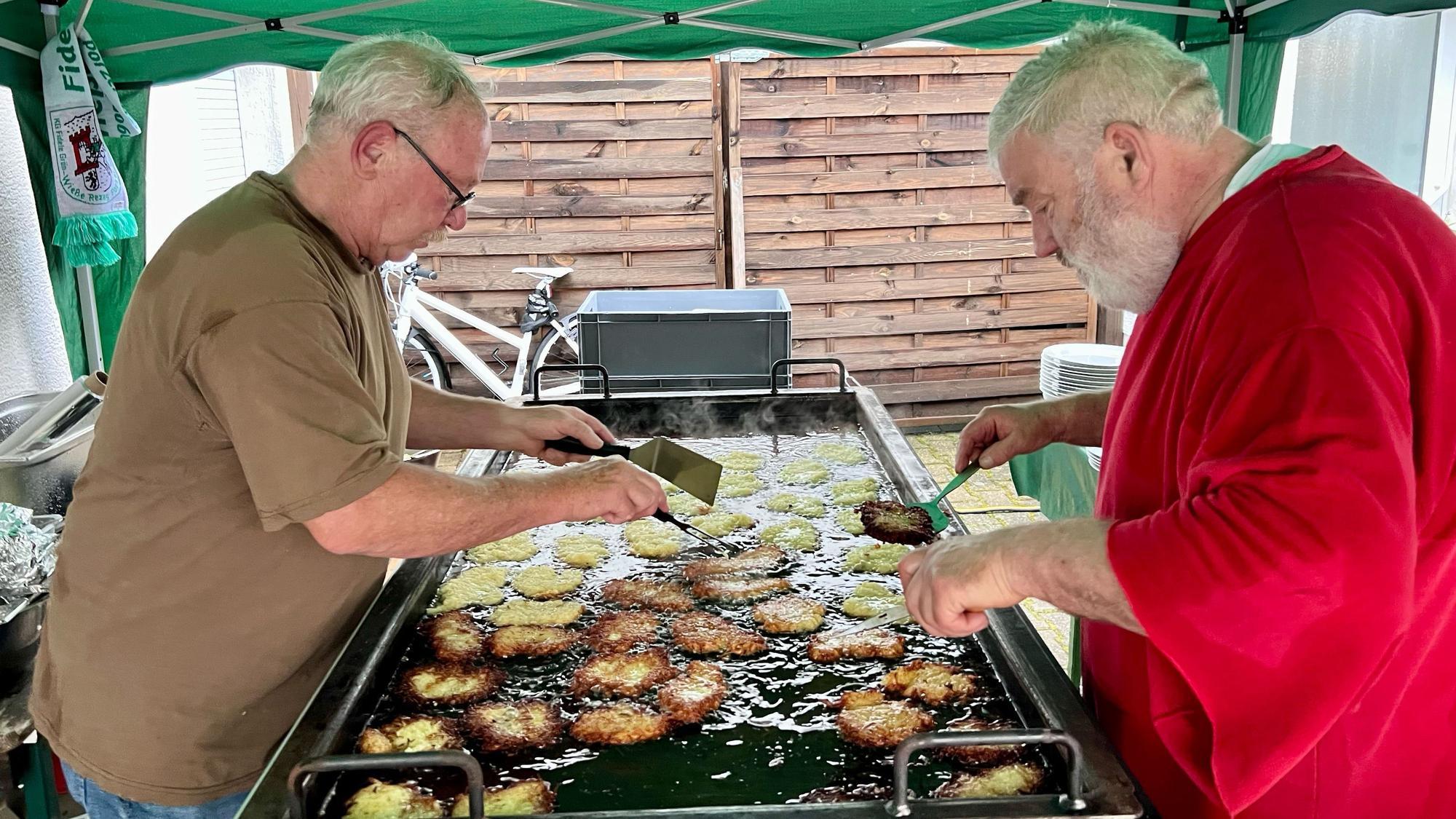 Reibekuchen im Akkord: Manfred Haller (l.) und Heinz Hönscheid backen für den guten Zweck.