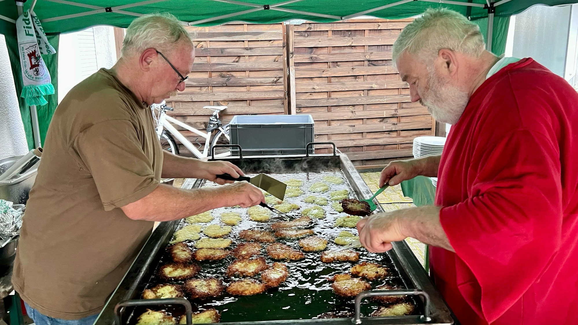 Reibekuchen im Akkord: Manfred Haller (l.) und Heinz Hönscheid backen für den guten Zweck.