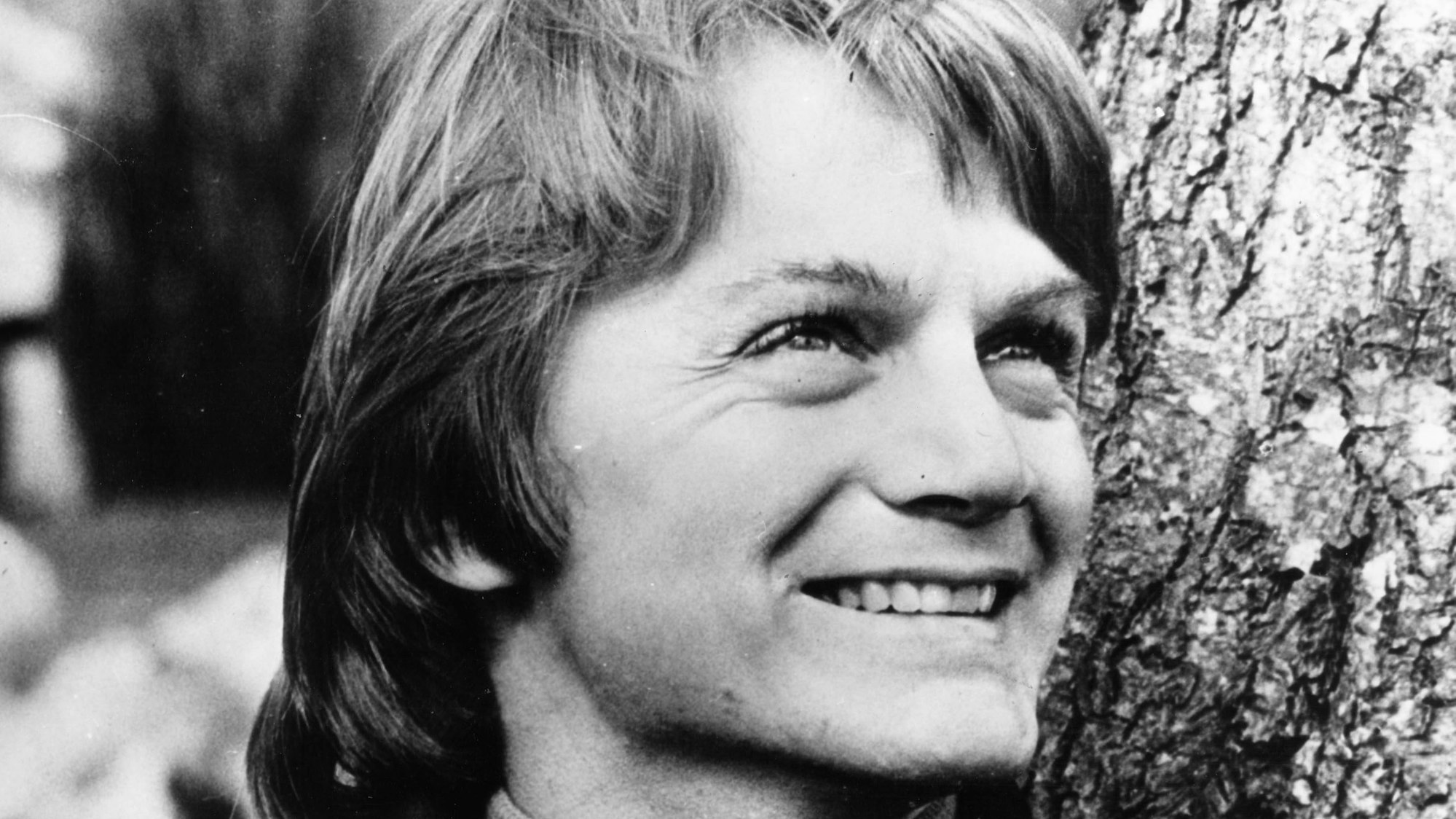 Claude François lacht und schaut in die Ferne.