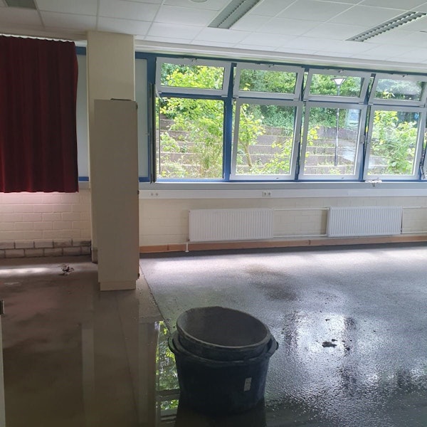 Ineinander gestapelte Eimer stehen auf dem noch nassen Boden.