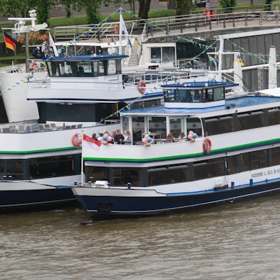 Zu sehen sind zwei Schiffe, die den Rhein entlangfahren.