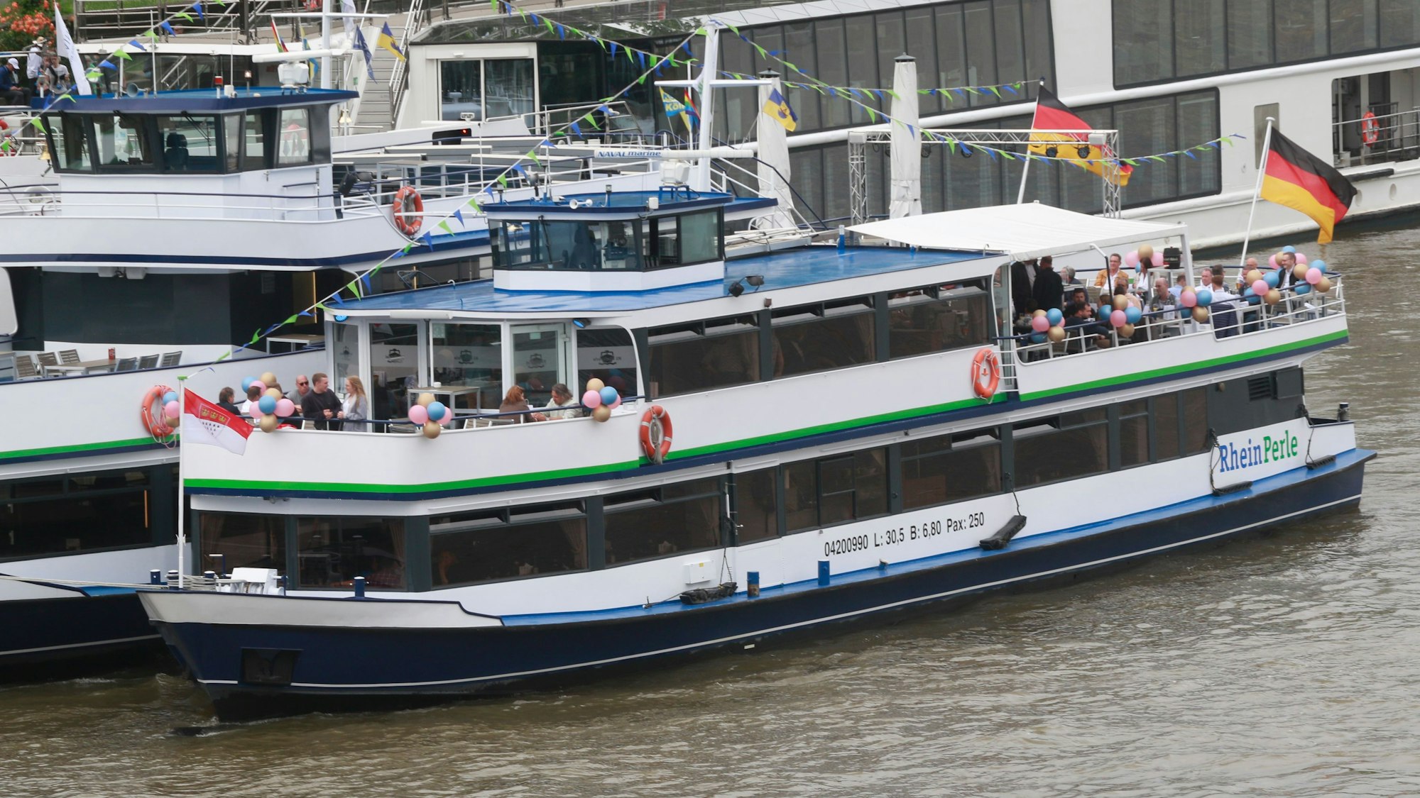 Zu sehen sind zwei Schiffe, die den Rhein entlangfahren.