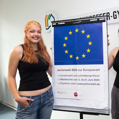 Zwei Schülerinnen vor einem Plakat.