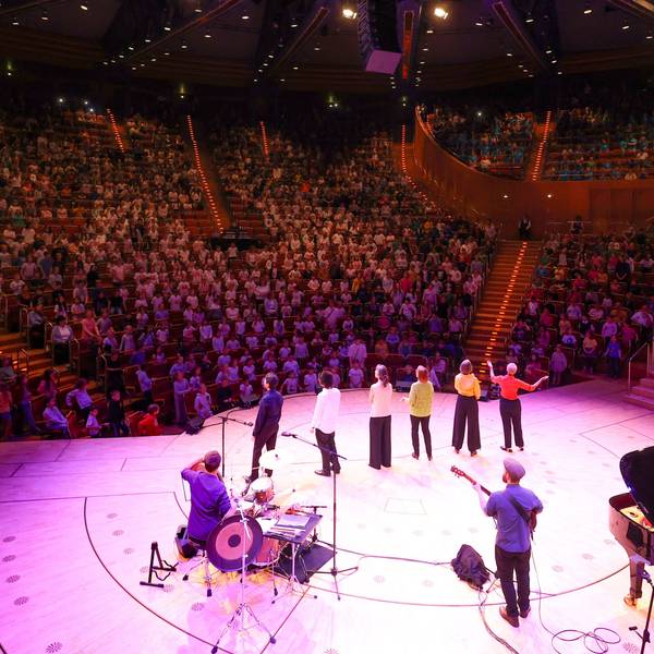 Fast alle Reihen der Kölner Philharmonie sind mit 1.300 Grundschülern besetzt, die von einer Band begleitet ein Konzert geben.